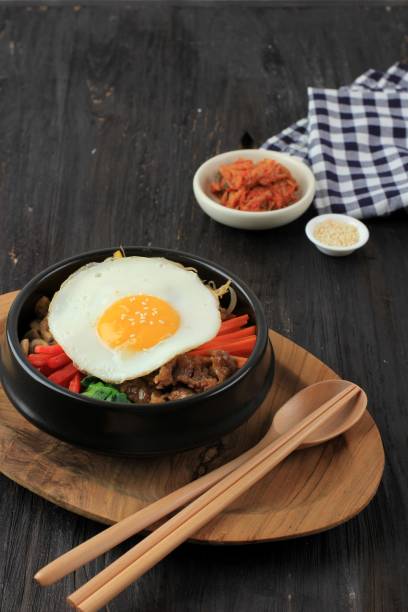 Bibimbap Rice with Mix Sautee Vegetables, Beef,  and Egg. Served with Red Spicy Bibimbap Sauce and Sesame Oil. Copy Space for Text stock photo