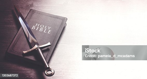 istock Bible and a Sword on a Dark Wooden Table 1303687372