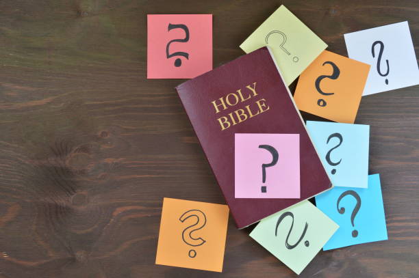 bible and colorful note pads with question marks stock photo