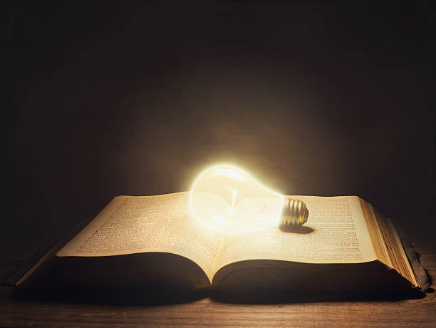 Bible with light bulb stock photo