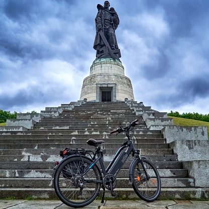 Berlin, Germany, June 20, 2022: Bicycle in front of the steps at the soviet memorial in Berlin with dark clouds in the background, bicycle tour Berlin