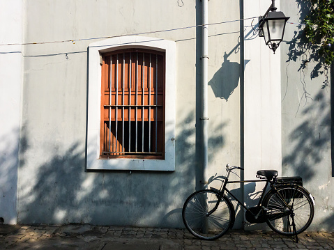 Pondicherry. India - February 2020: A bicycle parked outside the walls of an old French building in the city of Pondicherry.