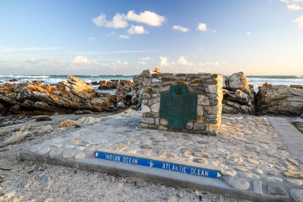 Big marker stone at Cape Agulhas(Cape of the Needles),South Africa,southernmost point of the African continent.It marks the division point between the Atlantic and Pacific Ocean. Big marker stone at Cape Agulhas(Cape of the Needles),South Africa,southernmost point of the African continent.It marks the division point between the Atlantic and Pacific Ocean. headland stock pictures, royalty-free photos & images