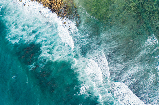 Bali, aerial shot of the turquoise ocean surface and waves.