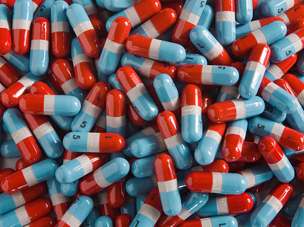 Big Pile of Pills Huge pile of red and blue pills.  Colors have been altered so they don't violate any copyright. amphetamine stock pictures, royalty-free photos & images