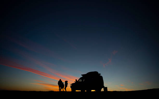 Big Red Sunset A young family watches the sunset on top of the 'Big Red' sand dune in the Australian outback 4x4 stock pictures, royalty-free photos & images