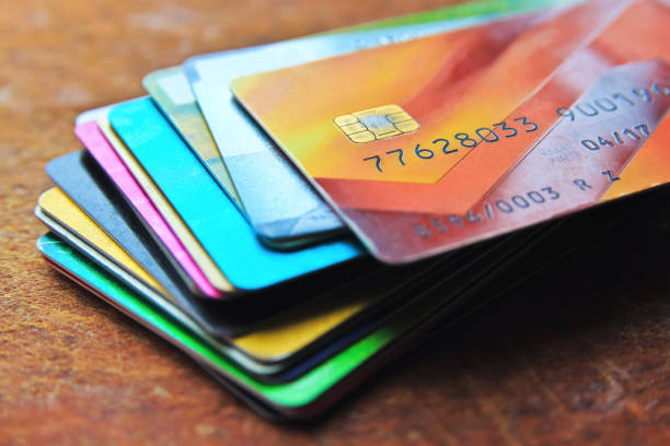 Big stack of multicolored credit cards on a wooden background stock photo