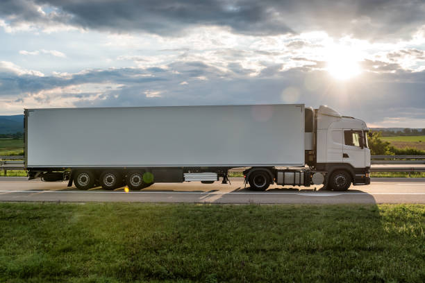 Big White truck on highway White truck is on highway - business, commercial, cargo transportation concept, beautiful sunset sky, clear and blank space - side view semi truck side view stock pictures, royalty-free photos & images