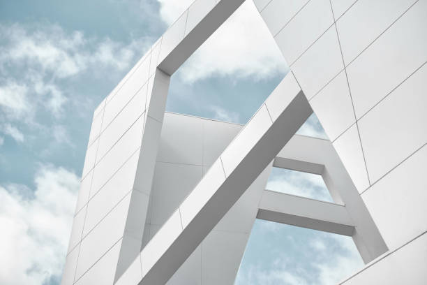 Big white walls against the blue sky Big white walls of the building against the blue sky and white clouds. Modern architecture. Minimalistic design architecture stock pictures, royalty-free photos & images