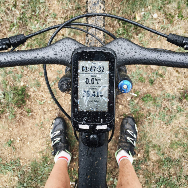 Bike computer navigator on black carbon bicycle in the rain. Waterproof display and activity data on screen. Modern technology stock photo