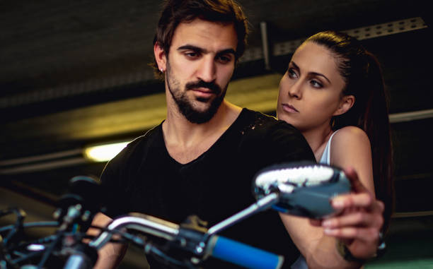 Biker looking at the mirror while his girlfriend is angry stock photo