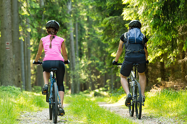 Bikers in forest cycling on track stock photo