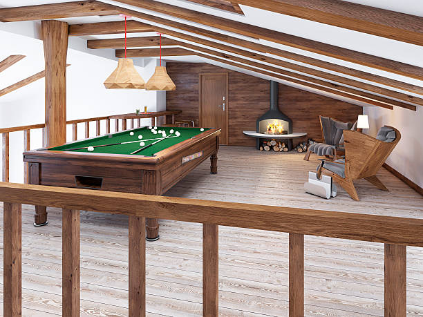 Billiard room in the attic with sitting area and fireplace. stock photo
