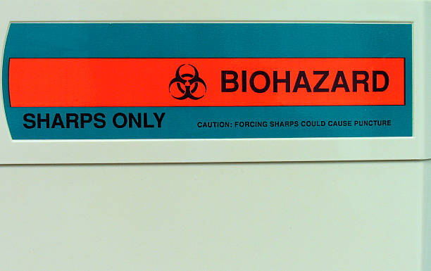 Biohazard label on sharps container in the medical office. stock photo