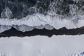 istock Bird's Eye View of the Black Sand Beach With Snow in Iceland 1360001944