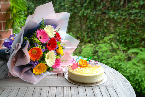 Birthday cake with bouquet of colorful gerbera daisies stock photo