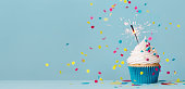 istock Birthday cupcake with sparkler and falling confetti 1315030969