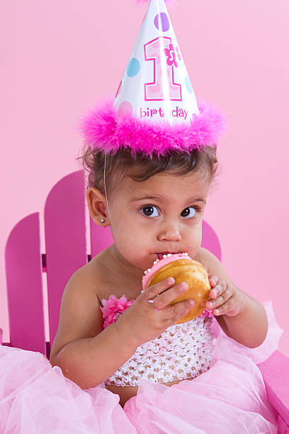 Birthday Girl with Cupcake Adorable little girl on her 1st birthday with party hat and cupcake. Click on image below to view more baby pictures in my Babies lightbox. cute puerto rican girls stock pictures, royalty-free photos & images