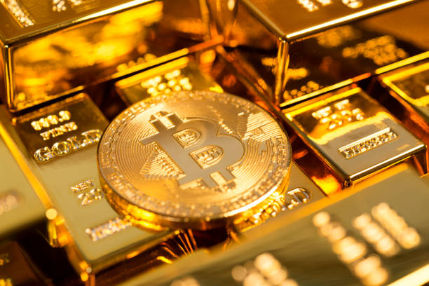 Bitcoin among gold bars stock photo