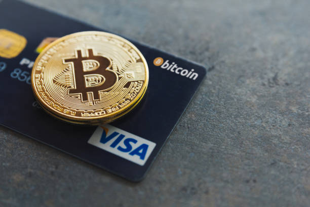A bitcoin and a Visa credit card on a textured background. Pay with cryptocurrencies wherever you want in more than 40 million places around the world. Bitcoin as new money stock photo
