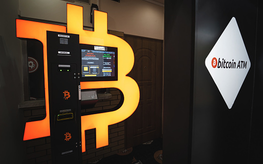 Bitcoin ATM in a mall allows to buy and sell Bitcoin crypto. Orange BTC cryptocurrency exchange machine. Warsaw, Poland - October 23, 2021