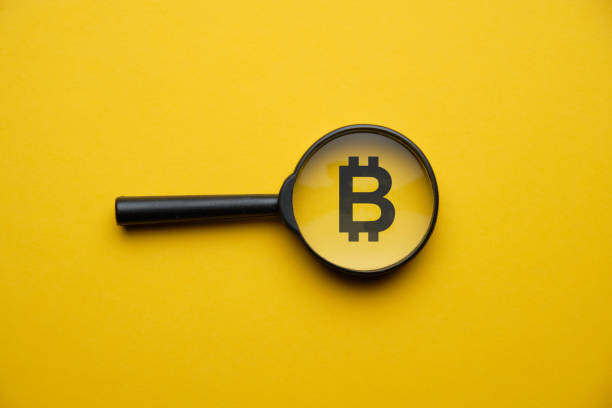 concepto de búsqueda de criptomonedas bitcoin con lupa sobre un fondo amarillo. - bitcoin fotografías e imágenes de stock