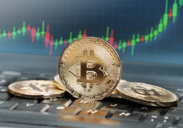 Bitcoin value rising Bitcoins on keyboard with screen in the background displaying rising trend of its value bitcoin photos stock pictures, royalty-free photos & images