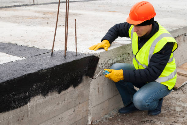 bitumen waterproofing of the foundation construction worker makes bituminous waterproofing of the foundation at the construction site membrane stock pictures, royalty-free photos & images