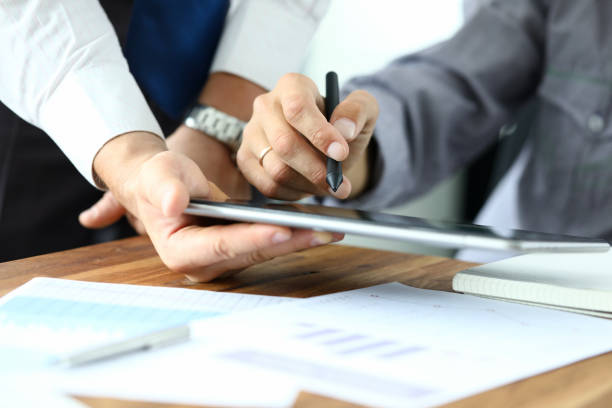 Biz communication between colleagues Focus on workers hands holding tablet. Manager giving for signature e-documents. Director signing important contract. Business concept. Blurred background endorsing stock pictures, royalty-free photos & images