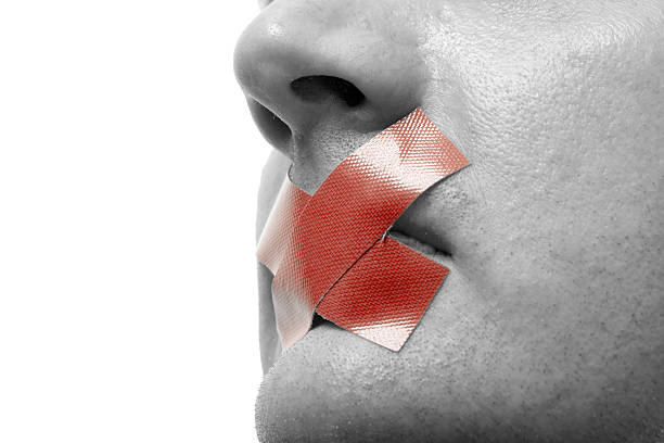 Black and white close-up face with red X taped over mouth stock photo
