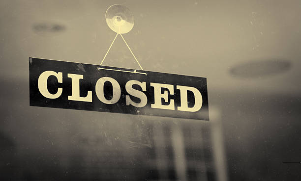 Black and white closeup of a Closed sign hanging on a window stock photo