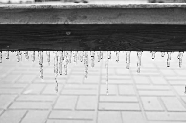 Black and white icicle on a wooden bench after a frozen rain stock photo