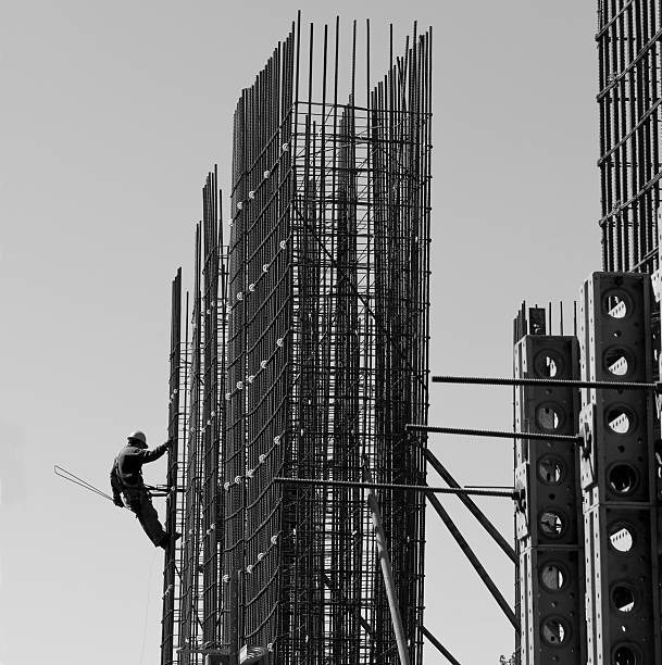 Black and white photo of construction worker on supports stock photo