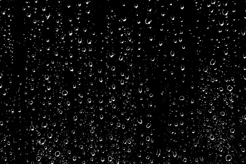 Drops of rain on glass in black and white.... background.