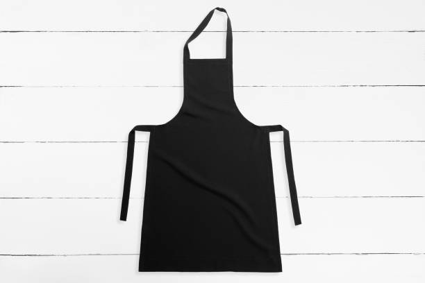 Black apron Blank black apron on white wooden background apron stock pictures, royalty-free photos & images