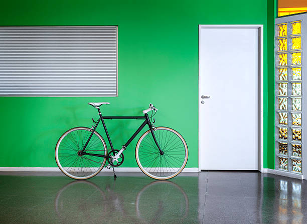 Black bicycle against a green wall stock photo