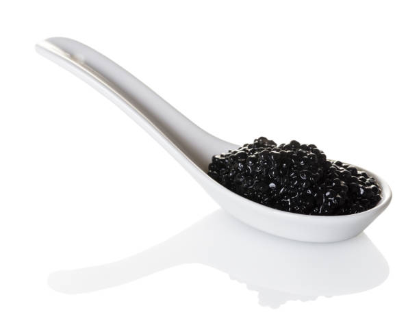 black caviar in spoon black caviar in spoon on white isolated background roe stock pictures, royalty-free photos & images