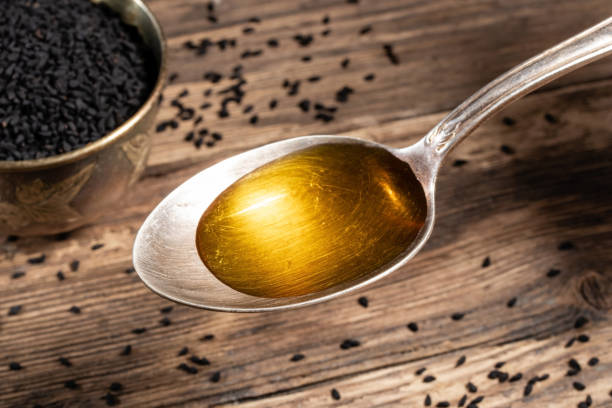 Black cumin seed oil on a spoon stock photo