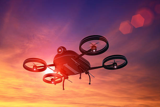 Black drone flying in the sky at sunset, lens flare stock photo