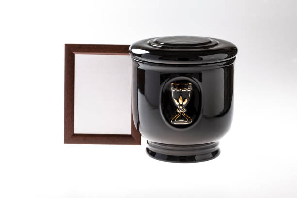 Black evangelical urn with blank mourning frame, and flower Black evangelical urn with blank mourning frame, and flower on bright background funerary urn stock pictures, royalty-free photos & images
