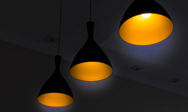 Black fixtures of yellow lamp with black background  for interior design stock photo