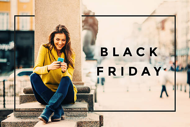 Black Friday A young woman texting on the phone outdoors. black friday shoppers stock pictures, royalty-free photos & images