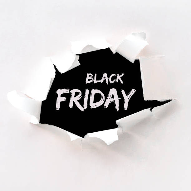 zwarte vrijdag tekst in papier gat geplakt in wit papier over zwarte achtergrond - black friday stockfoto's en -beelden