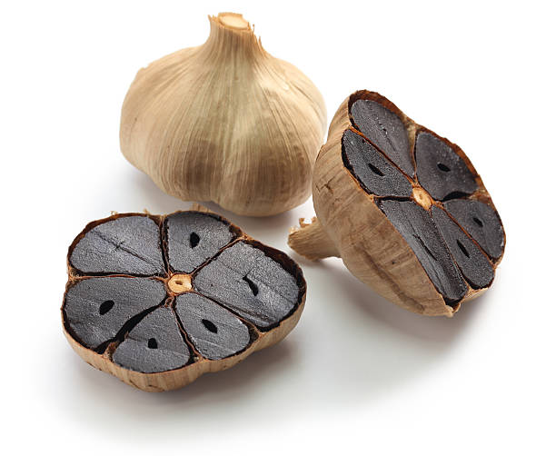 black garlic black garlic bulbs and cloves on white background garlic stock pictures, royalty-free photos & images