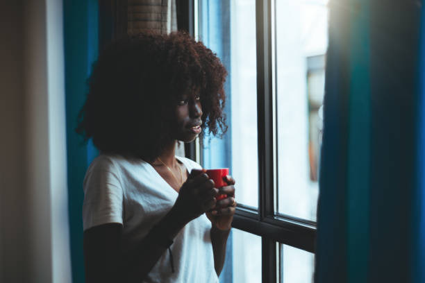 Black girl, cup of coffee, window stock photo