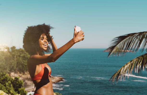 Black girl vlogging on the beach stock photo