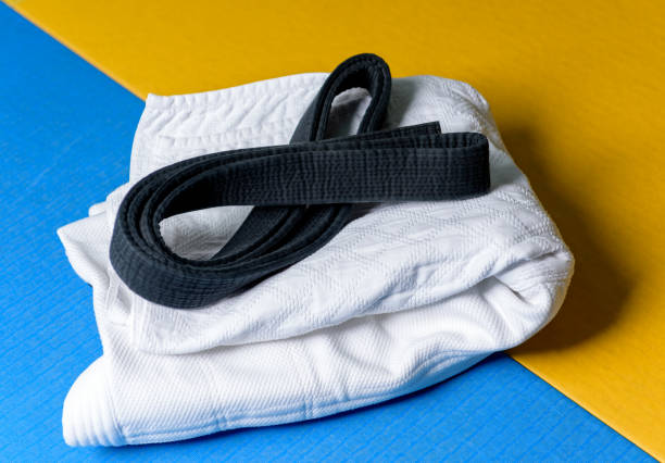 Black judo, aikido or karate belt on white judo gi Black judo, aikido or karate belt on white judo gi bushido lifestyle stock pictures, royalty-free photos & images
