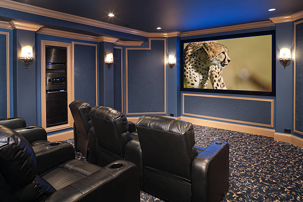 Black leather chairs adorn a beautiful home theatre. stock photo