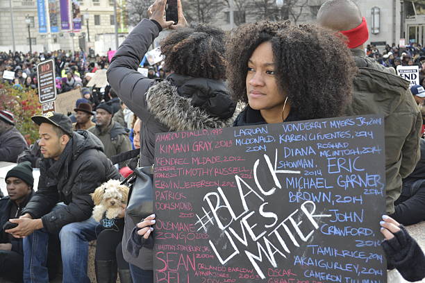 Black Lives Matter Washington D.C., USA - December 13, 2014: A young woman holds a sign at the protest march in Washington DC to bring attention to the recent shooting deaths of several unarmed black men by police. racism stock pictures, royalty-free photos & images
