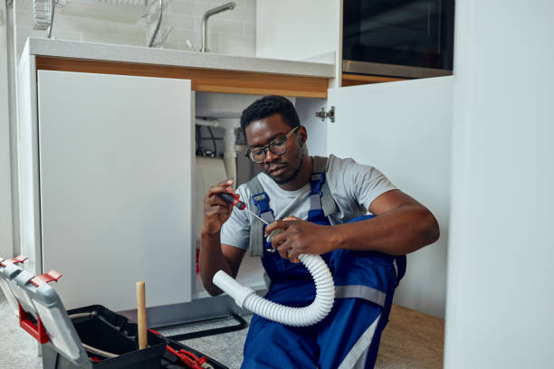 Black male plumber at work Black plumber in uniform fixing kitchen sink He is sitting on the floor in kitchen and holding pipe african american plumber stock pictures, royalty-free photos & images